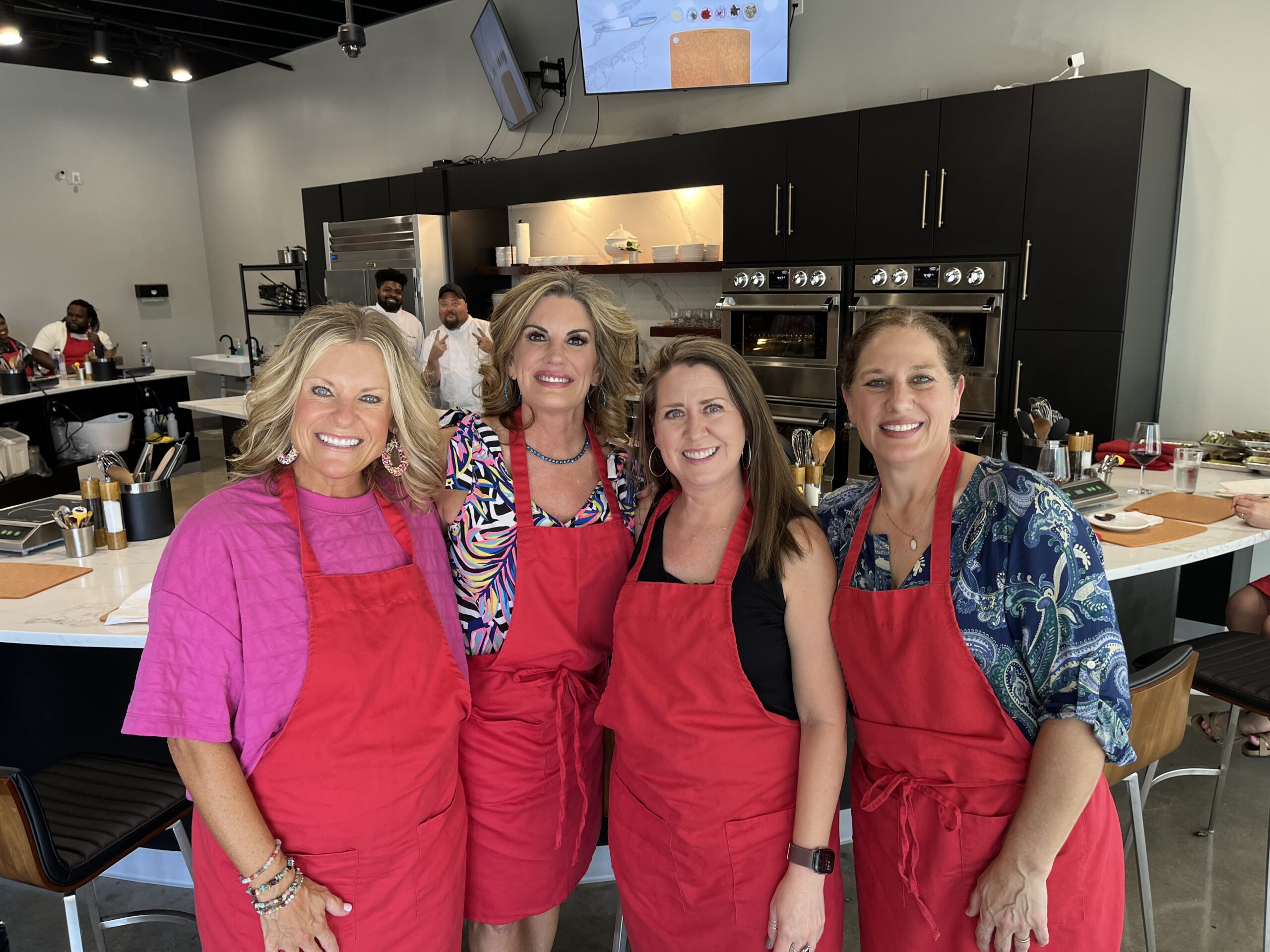 Excited women smiling after cooking at a Kitchen Social class in Dallas, Texas.